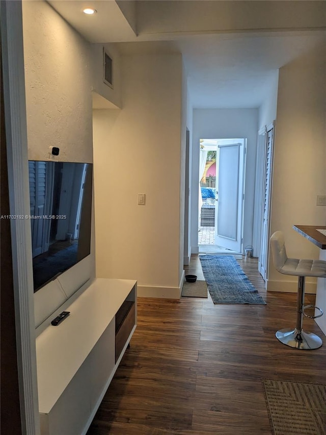interior space with visible vents, baseboards, and dark wood-style floors