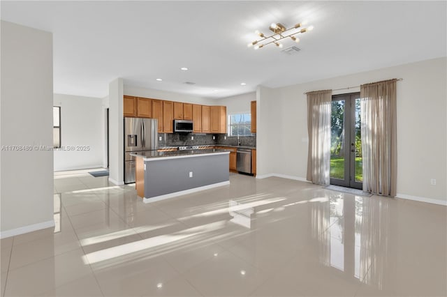 kitchen with stainless steel appliances, a wealth of natural light, visible vents, and decorative backsplash