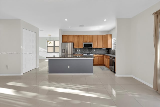 kitchen with appliances with stainless steel finishes, a center island, light tile patterned flooring, and decorative backsplash