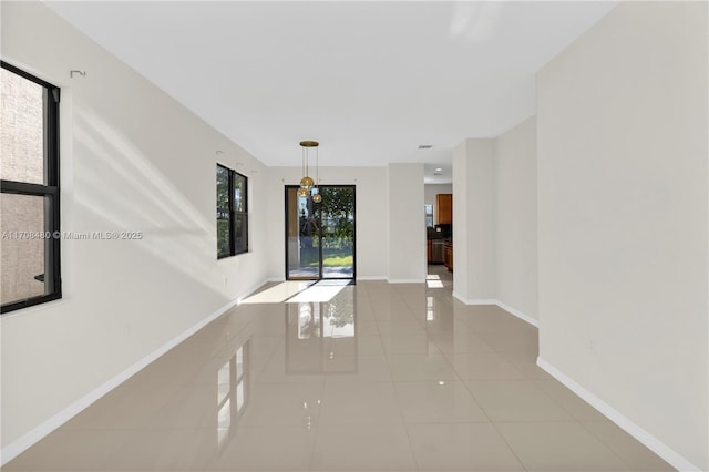 empty room with light tile patterned flooring and baseboards