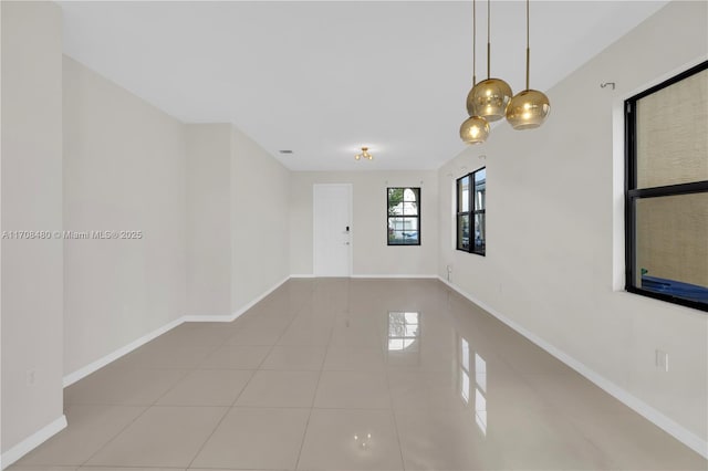 unfurnished room with baseboards and tile patterned floors