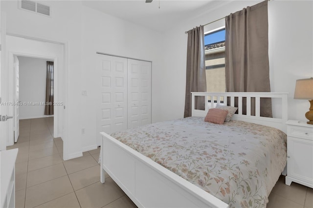 bedroom featuring light tile patterned floors, a ceiling fan, visible vents, and a closet