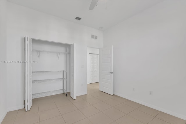 unfurnished bedroom featuring light tile patterned floors, baseboards, visible vents, and a closet