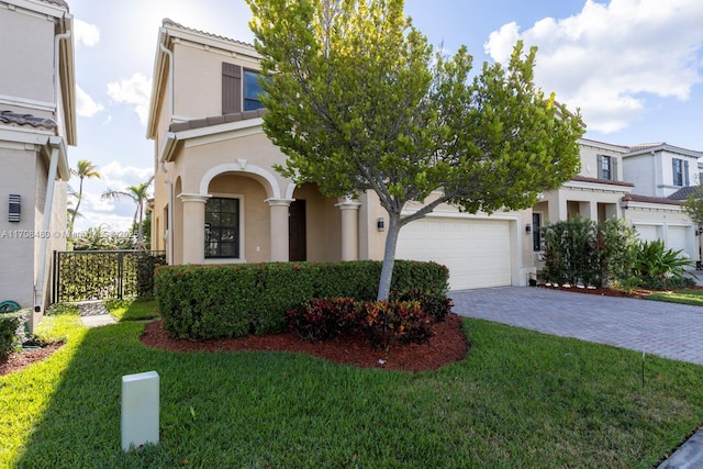 view of front of property featuring a garage, a front lawn, decorative driveway, and stucco siding