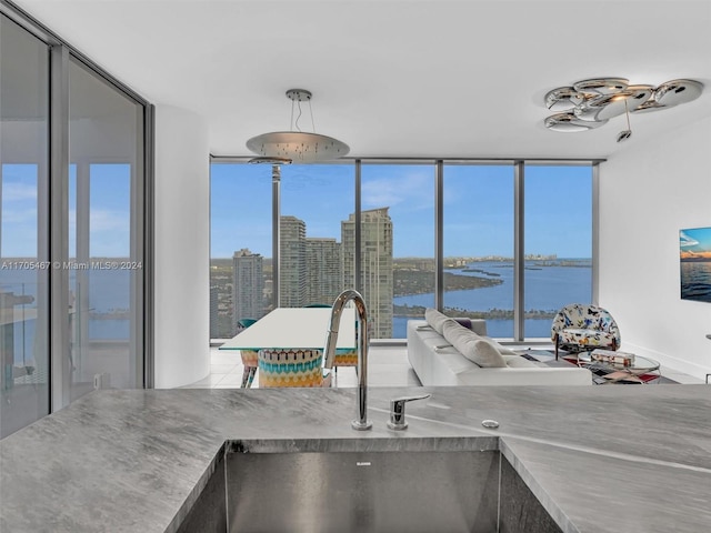 kitchen with decorative light fixtures, expansive windows, and sink