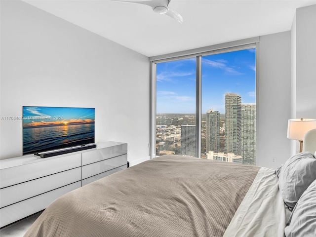 bedroom with a wall of windows and ceiling fan