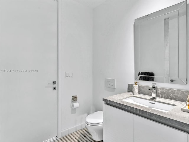 bathroom featuring tile patterned flooring, vanity, and toilet