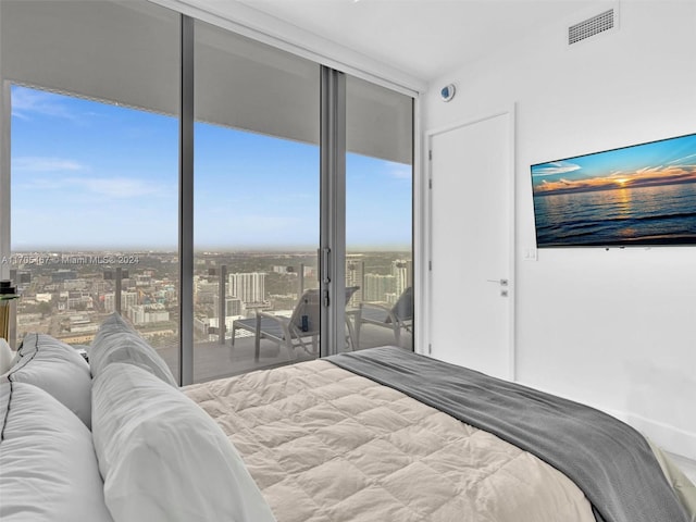 bedroom featuring access to exterior and a wall of windows