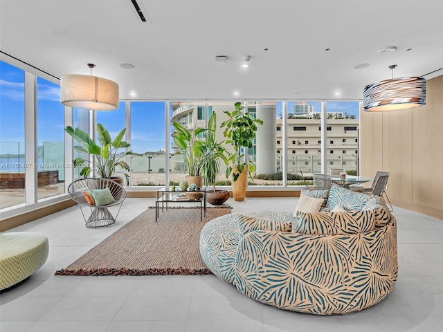 living room with plenty of natural light, a wall of windows, and light tile patterned floors