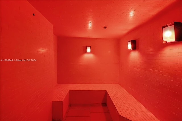 view of sauna featuring tile patterned flooring and brick wall