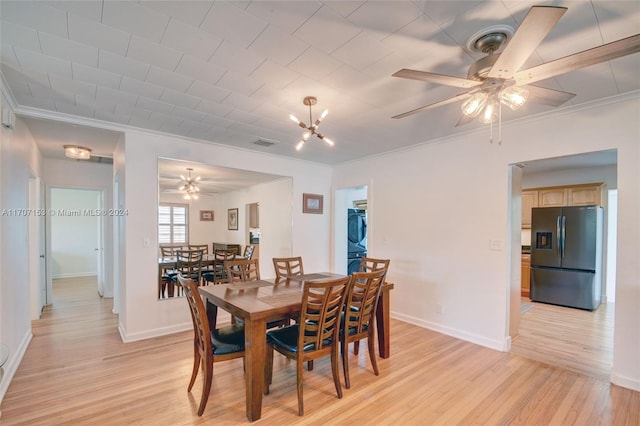 dining room with ceiling fan, light hardwood / wood-style flooring, stacked washing maching and dryer, and ornamental molding