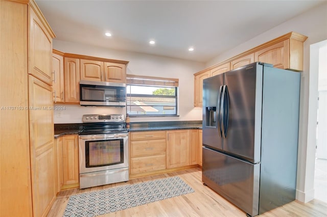 kitchen with appliances with stainless steel finishes, light brown cabinets, and light hardwood / wood-style flooring