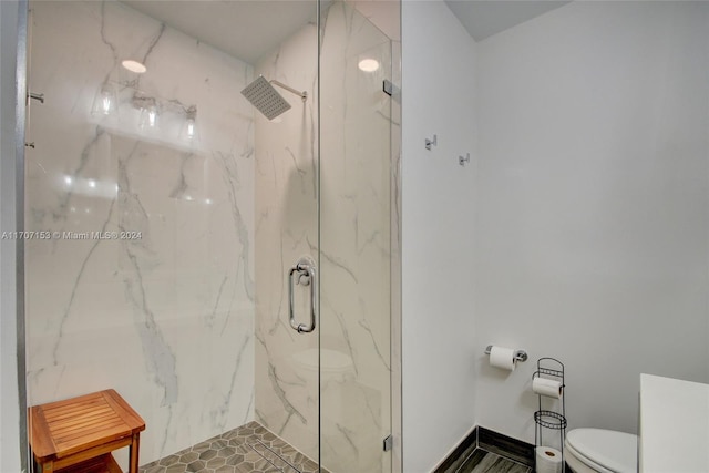 bathroom with toilet and a shower with shower door