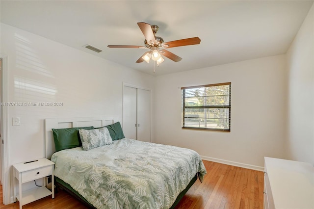 bedroom with hardwood / wood-style flooring, ceiling fan, and a closet