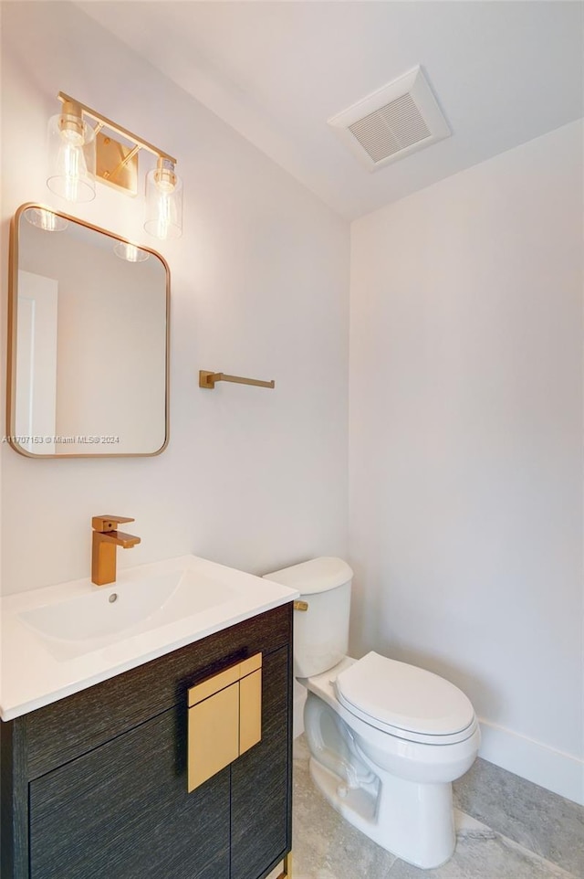 bathroom with tile patterned flooring, vanity, and toilet