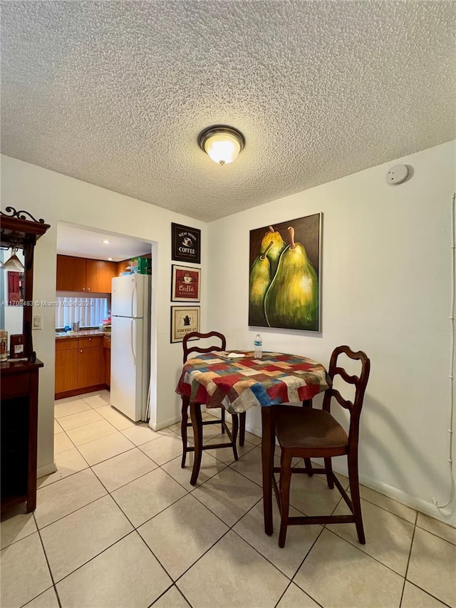 tiled dining room with a textured ceiling