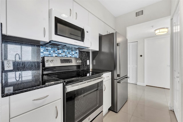 kitchen featuring light tile patterned flooring, white cabinetry, backsplash, and appliances with stainless steel finishes