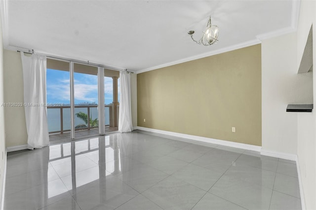 empty room with floor to ceiling windows, crown molding, light tile patterned floors, a water view, and a notable chandelier