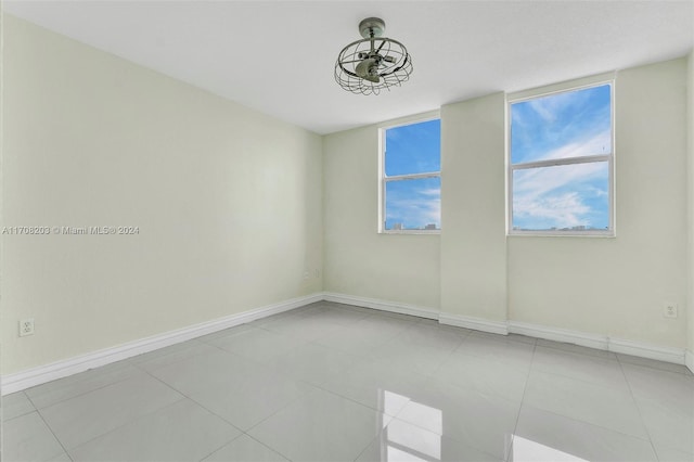 empty room featuring ceiling fan and light tile patterned floors