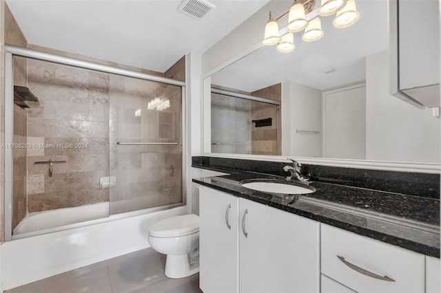 full bathroom featuring shower / bath combination with glass door, tile patterned floors, vanity, and toilet