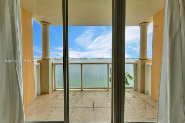 interior space with a water view and light tile patterned floors