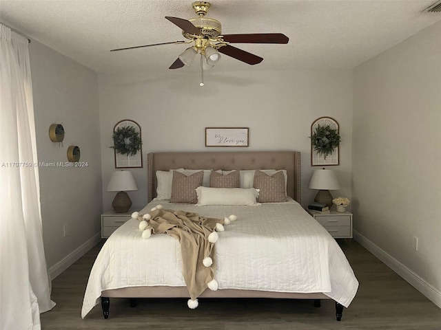 bedroom with a textured ceiling, dark hardwood / wood-style flooring, and ceiling fan