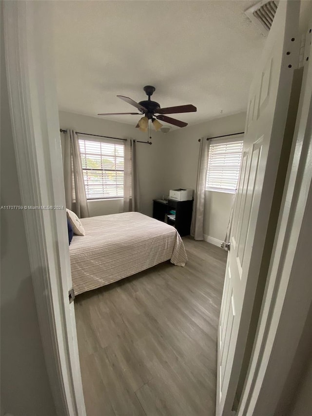 bedroom with ceiling fan and light hardwood / wood-style flooring