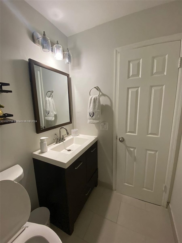 bathroom with tile patterned flooring, vanity, and toilet