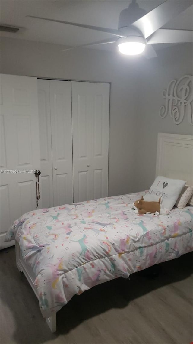 bedroom featuring ceiling fan, wood-type flooring, and a closet