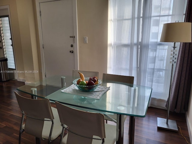 dining room with dark wood-type flooring and a healthy amount of sunlight