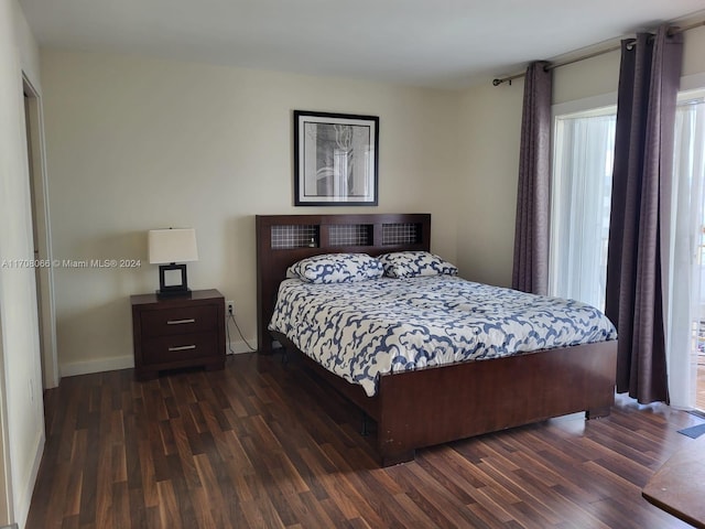 bedroom with multiple windows and dark wood-type flooring