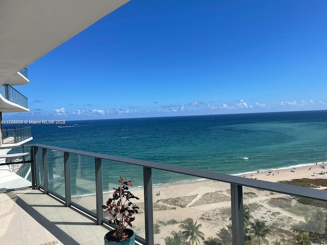 balcony with a water view and a beach view