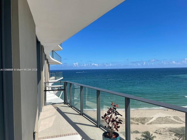 balcony with a water view and a beach view