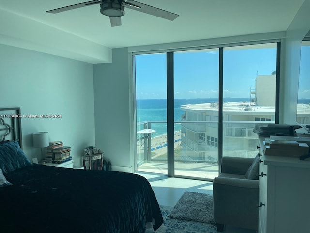 bedroom with ceiling fan, expansive windows, a water view, and multiple windows