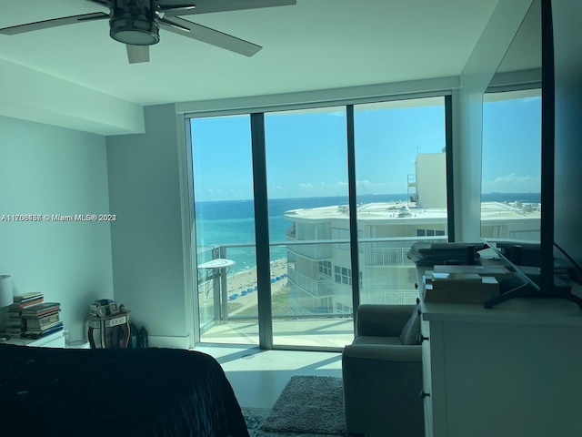 bedroom with floor to ceiling windows, a water view, multiple windows, and ceiling fan