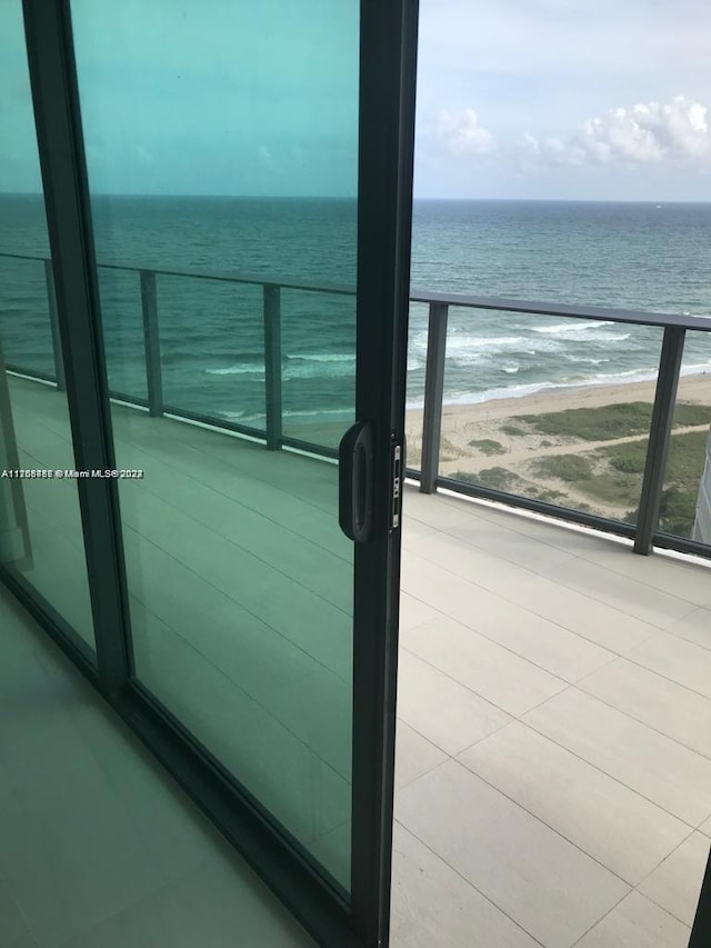 balcony featuring a water view and a beach view