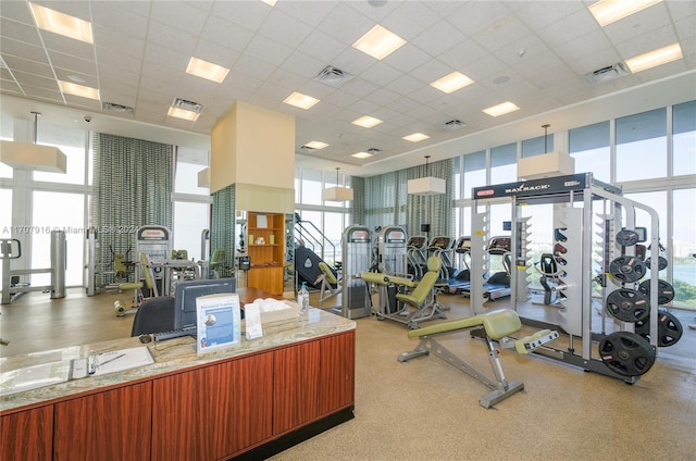 exercise room featuring a paneled ceiling and expansive windows