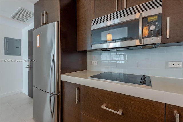 kitchen with pendant lighting, electric panel, light tile patterned floors, dark brown cabinetry, and stainless steel appliances