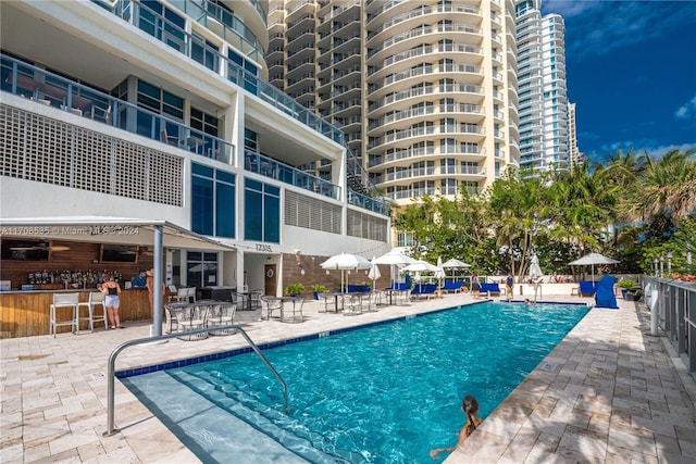 view of swimming pool with exterior bar and a patio