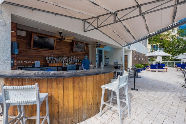 view of patio / terrace featuring ceiling fan and exterior bar