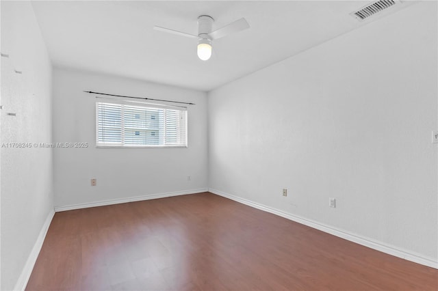 spare room with dark wood-type flooring and ceiling fan