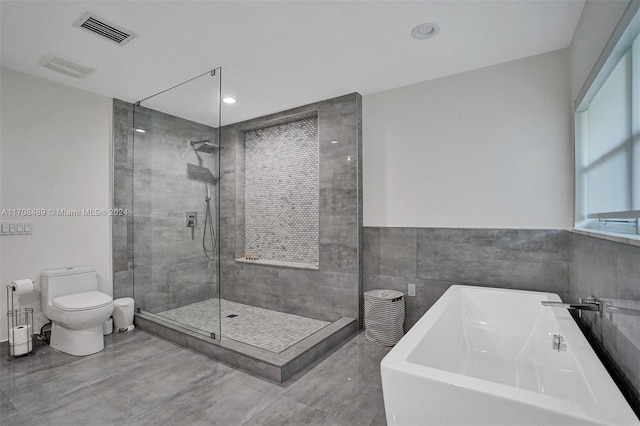 full bathroom with sink, independent shower and bath, tile walls, and toilet