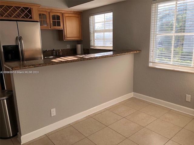 kitchen featuring light tile patterned floors, sink, and dark stone countertops