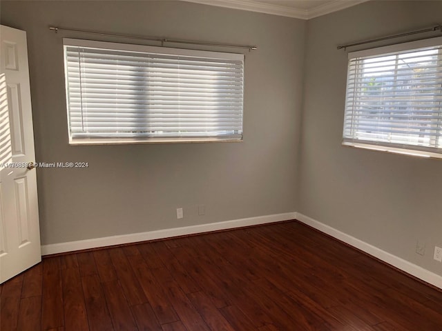 empty room featuring dark hardwood / wood-style flooring and crown molding