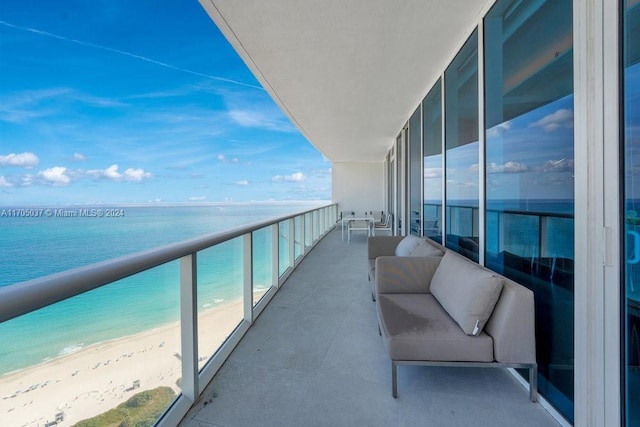 balcony with a beach view, an outdoor hangout area, and a water view