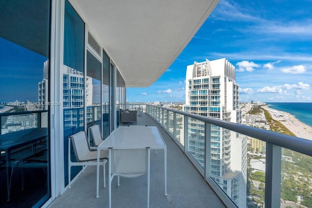 balcony with a water view and a view of the beach