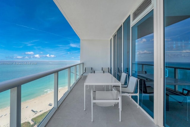 balcony featuring a water view and a view of the beach