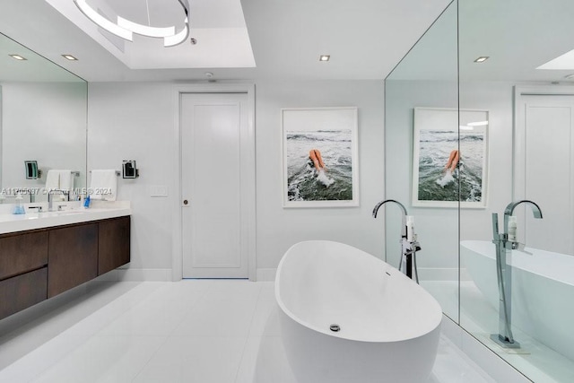 bathroom featuring tile patterned flooring, vanity, a raised ceiling, and a bath