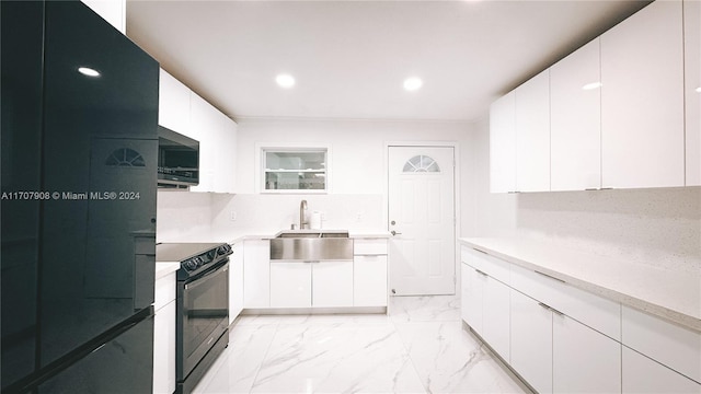 kitchen featuring sink, white cabinets, and black appliances