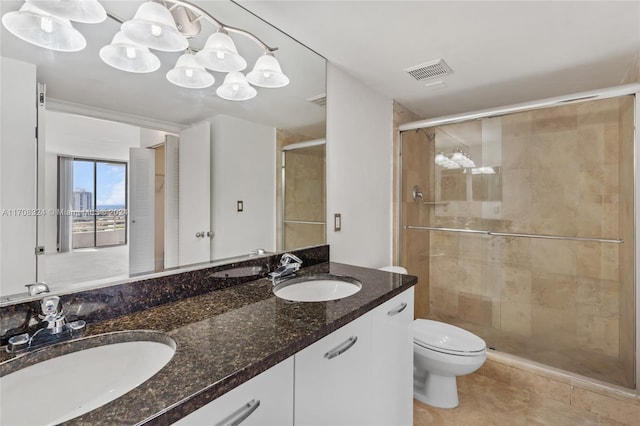 bathroom with tile patterned flooring, vanity, toilet, and a shower with shower door